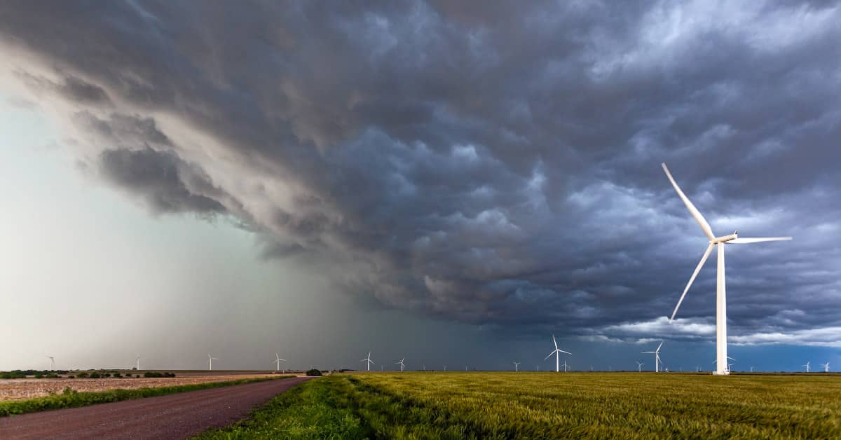 a dark sky showing severe weather approaching over a wind farm