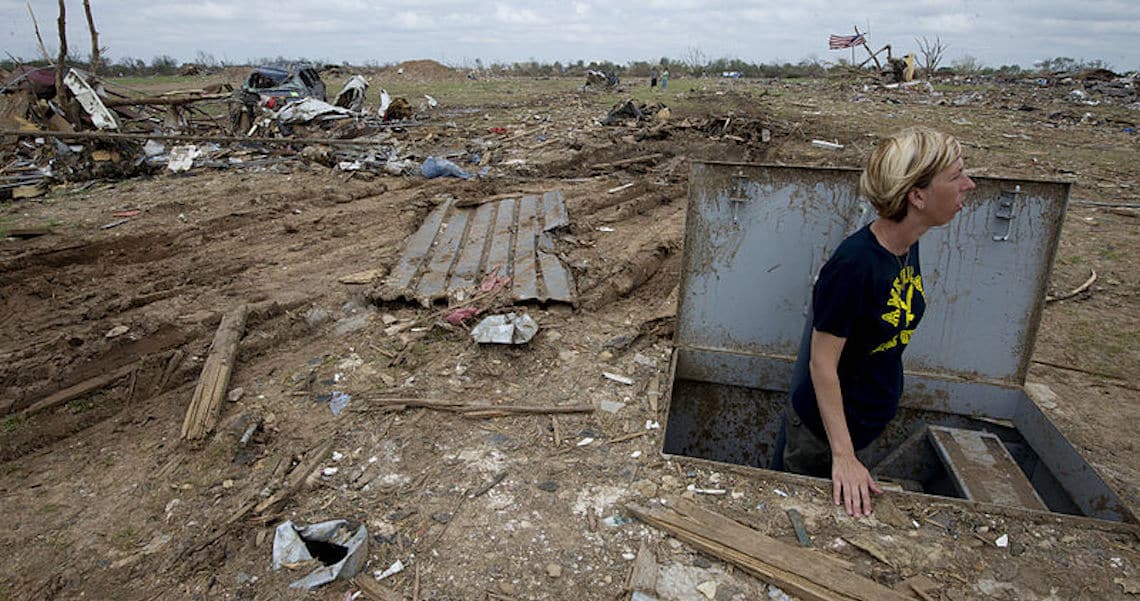 image of a woman coming out of a tornado shelter after a tornado