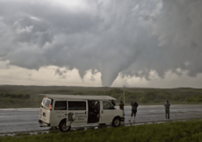 A storm tourism van with several possible tornados in the background