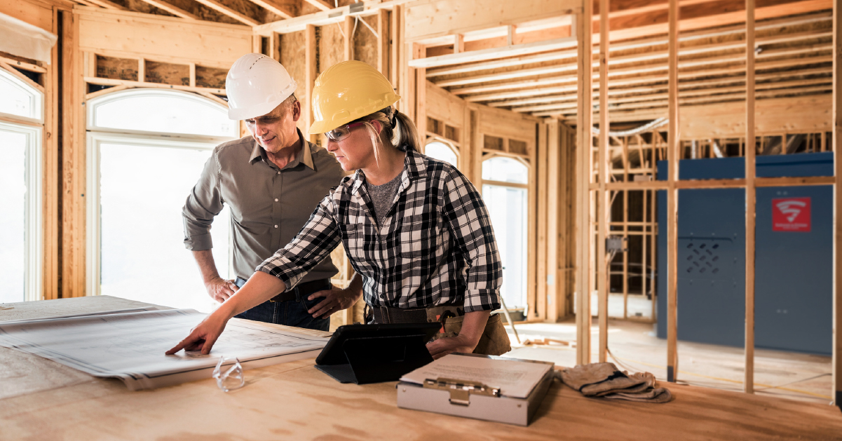 A contractor shows a homeowner on a blueprint where the new tornado shelter will be installed in their home layout.
