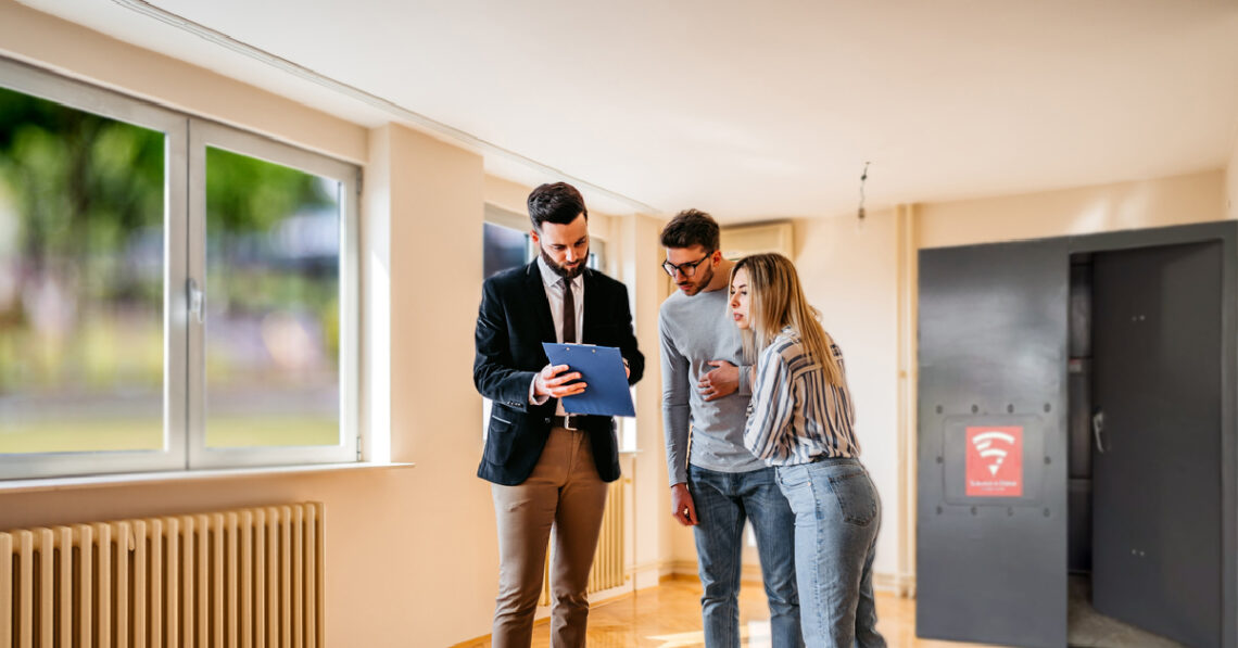 Realtor discussing a home's storm shelter with prospective buyers during a property showing.