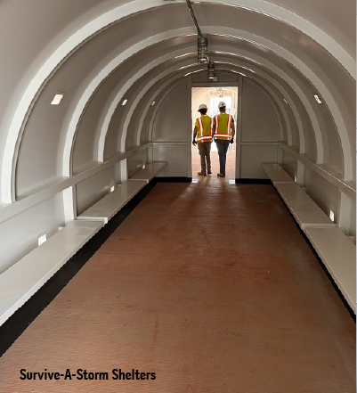 interior commercial tornado safe room Interior of a commercial tornado safe room with bench seating and workers standing at the entrance.