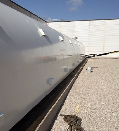 tornado shelter workplace Exterior of an above-ground workplace tornado shelter installed beside a commercial building.