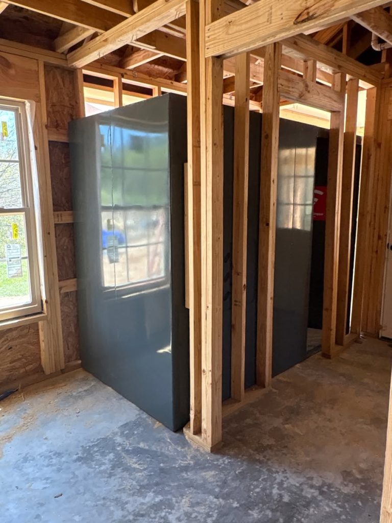 Steel tornado shelter integrated into the framed interior of a new home.