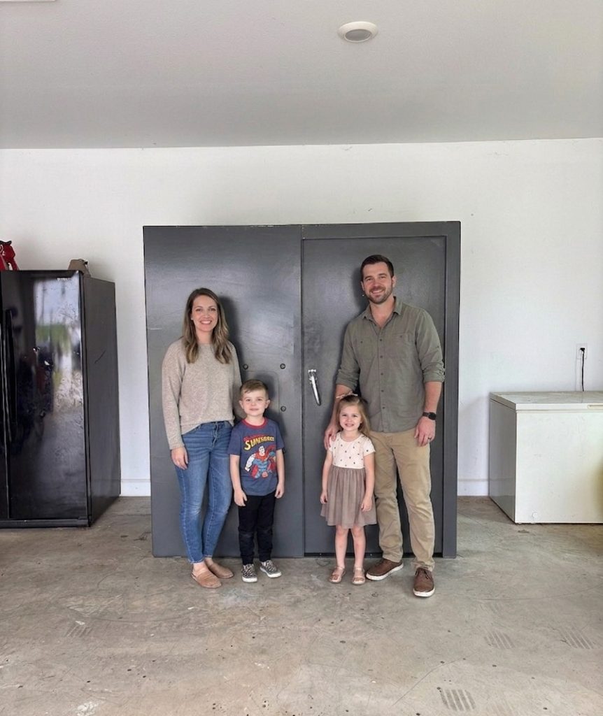 Family standing in front of their residential Survive-A-Storm shelter